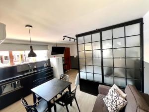 a kitchen and a living room with a table and chairs at Pousada Ilha do Campeche in Florianópolis