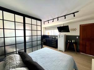 a room with a bed and a refrigerator and a tv at Pousada Ilha do Campeche in Florianópolis