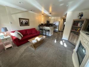 a living room with a red couch and a kitchen at Historic Washington St Balcony in Sonora