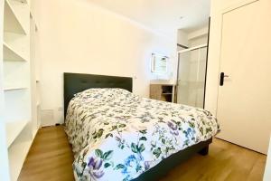 a bedroom with a bed with a floral bedspread at Studio Refait à Neuf sur la Route des Sanguinaires in Ajaccio