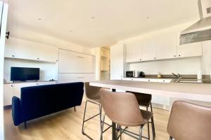 a kitchen with white cabinets and a table and chairs at Studio Refait à Neuf sur la Route des Sanguinaires in Ajaccio