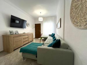 ein Wohnzimmer mit einem Sofa und einem TV in der Unterkunft Casa Romantica with ocean view in Alcalá