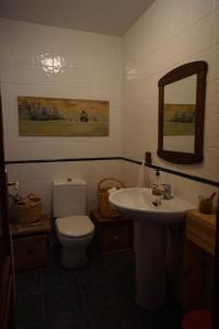ein Badezimmer mit einem Waschbecken, einem WC und einem Spiegel in der Unterkunft comfortable single bluing room b&b in Granada