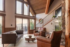 a living room with two couches and a table at Ponderosa Glen @ Ashley Lake in Kila