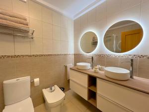 een badkamer met 2 wastafels en een toilet met 2 spiegels bij Casa Romantica with ocean view in Alcalá