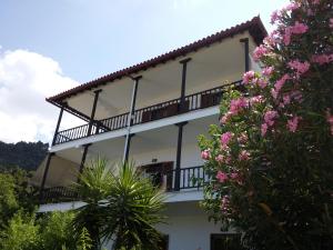 a white building with a balcony and pink flowers at Nikos & Panagiota in Vourvourou