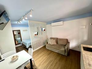 a small living room with a couch and a bed at Pousada Ilha do Campeche in Florianópolis