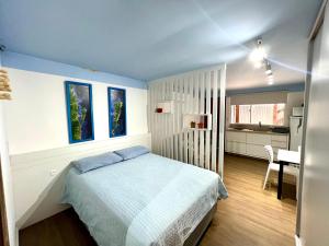 a bedroom with a bed and a kitchen with a table at Pousada Ilha do Campeche in Florianópolis