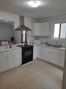 a kitchen with white cabinets and a black stove top oven at House -1 in Thunder Bay