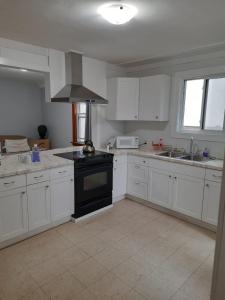 cocina con armarios blancos y fogones negros en House -1 en Thunder Bay