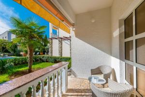 een balkon met rieten stoelen en een tafel bij Apartments Sinisa Malinska in Malinska