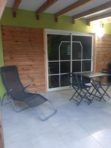 een patio met een tafel en stoelen in een kamer bij Zaboka delair in Sainte-Anne