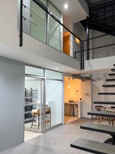 an open living room with a staircase and a table at SJO Oasis Hostel in San José