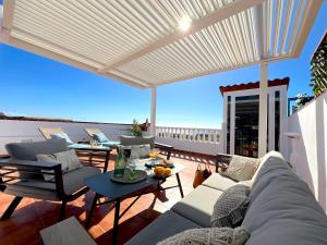 ein Wohnzimmer mit einem Sofa und einem Tisch in der Unterkunft Casa Romantica with ocean view in Alcalá