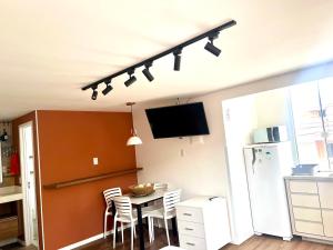 a kitchen with a table with chairs and a tv at Pousada Ilha do Campeche in Florianópolis
