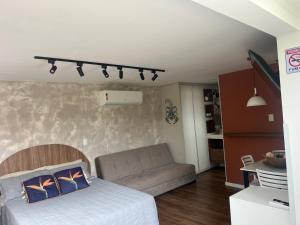 a bedroom with a bed and a couch at Pousada Ilha do Campeche in Florianópolis