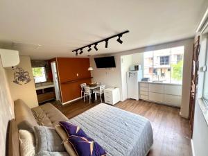 a living room with a bed and a kitchen at Pousada Ilha do Campeche in Florianópolis