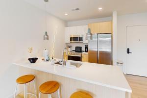 a kitchen with a white counter top and wooden stools at Life of the Party, Unit #418 in Nashville
