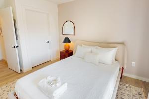 a bedroom with a bed with white sheets and pillows at Life of the Party, Unit #418 in Nashville +17 photos