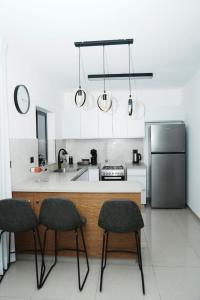 a kitchen with a counter and two chairs and a refrigerator at The best location in Jerusalem 1 in Jerusalem