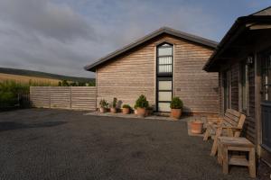 a house with a bench and potted plants in front of it at The Studio at The Grain Store in Falmer