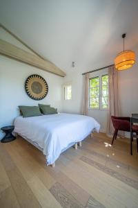 um quarto com uma grande cama branca e uma mesa em Calm villa with swimming pool & garden, within easy walking distance to village em Tourrettes-sur-Loup