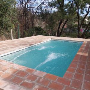 una piscina de agua azul en un patio en Casa completa en unquillo en Unquillo