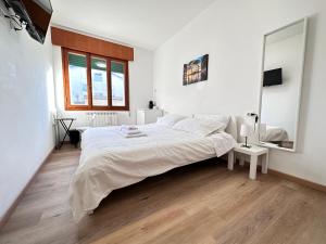 una camera bianca con un grande letto e uno specchio di Calima apartments a Marghera