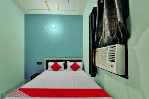 1 dormitorio con 1 cama con almohadas rojas en OYO Flagship Hotel R P Royal en Patna