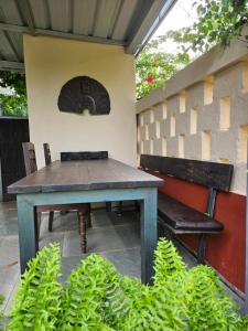 uma mesa e um banco ao lado de uma parede em Villa Mia em Mararikulam