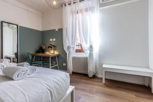 een slaapkamer met een wit bed en een raam bij Moline Home, in the City Center in Bologna