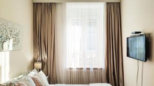 une chambre avec un lit et une fenêtre avec des rideaux dans l'établissement FilinHome Papa Studio 1, à Novi Sad
