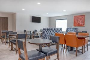 a waiting room with tables and chairs and a tv at Holiday Inn Express - Rensselaer, an IHG Hotel in Rensselaer