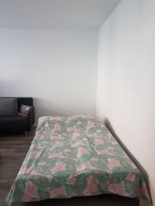 uma cama num quarto com um cobertor em Appartement 3 pièces RER C proche Paris Les Grésillons em Asnières-sur-Seine
