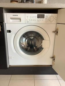 uma máquina de lavar roupa branca sentada numa cozinha em Appartement 3 pièces RER C proche Paris Les Grésillons em Asnières-sur-Seine
