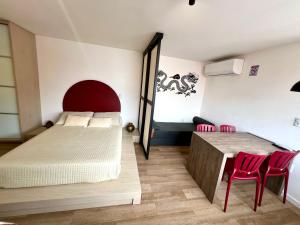 a bedroom with a bed and two red chairs at Pousada Ilha do Campeche in Florianópolis