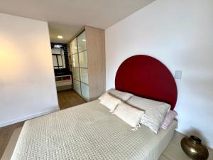 a bed with a red headboard in a room at Pousada Ilha do Campeche in Florianópolis