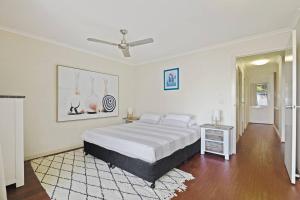 a white bedroom with a bed and a ceiling fan at Tangalooma Beachfront Villa 23 2 bedroom in Tangalooma