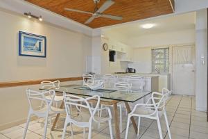 a dining room with a table and white chairs at Tangalooma Beachfront Villa 23 2 bedroom in Tangalooma