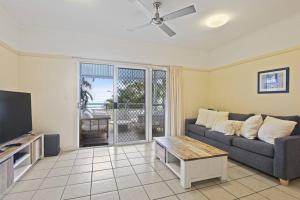 a living room with a couch and a tv at Tangalooma Beachfront Villa 23 2 bedroom in Tangalooma