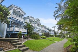 a row of apartment buildings with palm trees and a sidewalk at Tangalooma Beachfront Villa 23 2 bedroom in Tangalooma