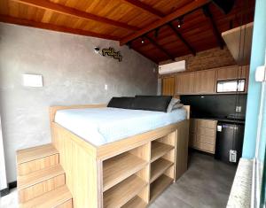 a bed in a small room with a kitchen at Pousada Ilha do Campeche in Florianópolis