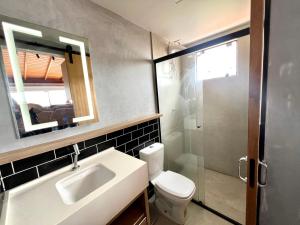 a bathroom with a sink and a toilet and a mirror at Pousada Ilha do Campeche in Florianópolis