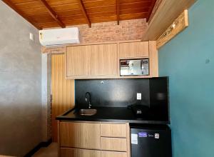 a small kitchen with a sink and a refrigerator at Pousada Ilha do Campeche in Florianópolis