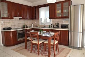 a kitchen with a table with chairs and a refrigerator at VILLAGE HOUSE in Tríkala