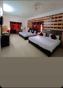 a bedroom with two beds and a brick wall at Collection O Hotel Gordon House in Katra