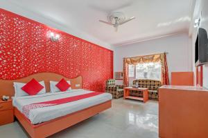 a bedroom with a bed and a red wall at Collection O Hotel Gordon House in Katra