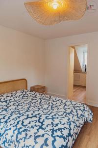 um quarto com uma cama com um edredão azul e branco em Le reflet chic - 2 pièces neuf - quartier calme à 5 min de Strasbourg em Schiltigheim
