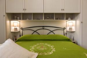 サレルノにあるLe Bijou Luxury Apartmentのベッドルーム(緑色のベッド、白いキャビネット付)