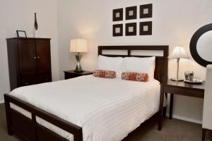 a bedroom with a large white bed with two pillows at El Primero Boutique Hotel in Chula Vista